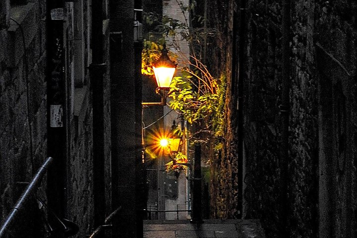 Wander through Edinburgh's shadowy alleys where tales of murderers and witches linger illuminated by flickering lamplights revealing the dark secrets of this historic city after sunset.